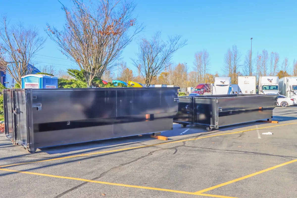 Professional dumpster rental service with roll-off container on residential driveway in Piney Green
